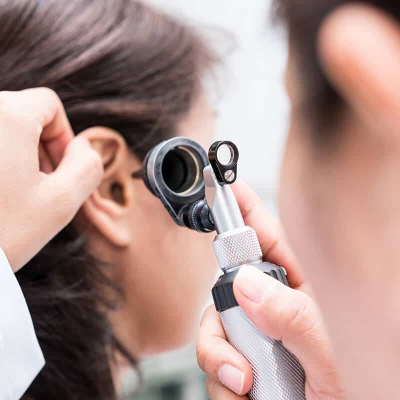 checking ear with otoscope