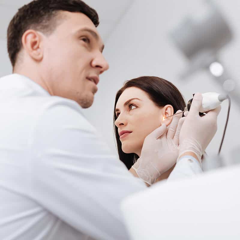 audiologist checking a patient's ear